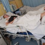 Kobieta na szpitalnym łózku, podłączona do aparatury.